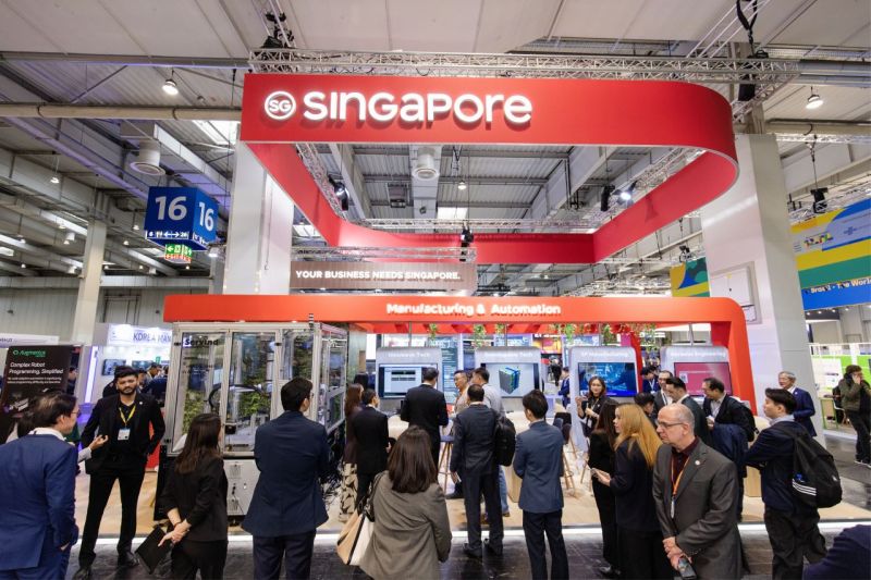 Besucher erkunden Ausstellungen zu Fertigung und Automatisierung am Singapur-Pavillon.