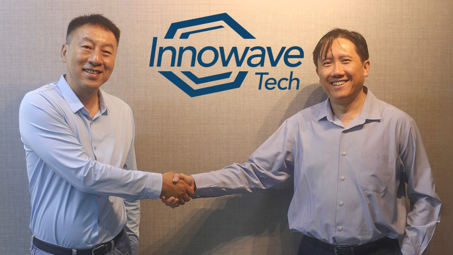 Zwei Führungskräfte geben sich vor dem Logo von Innowave Tech die Hand.
