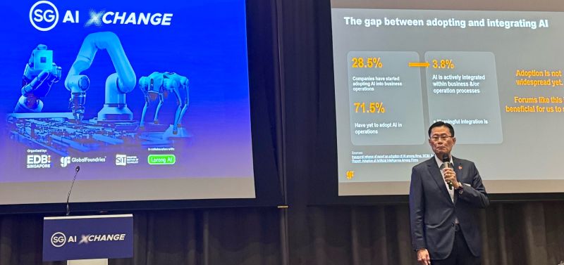 Speaker beside the SG AI Xchange event screen.